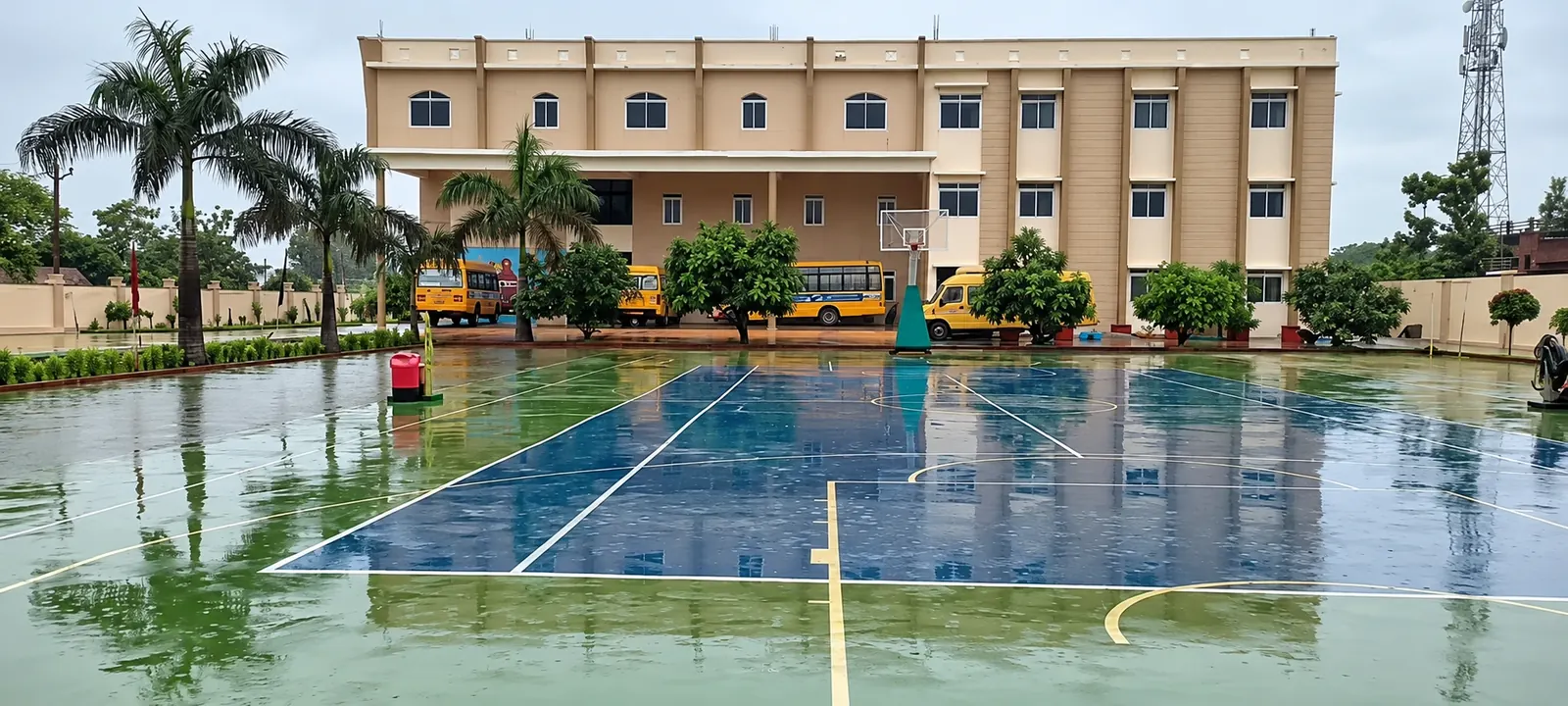 Maniram campus building and blue-and-green sports court